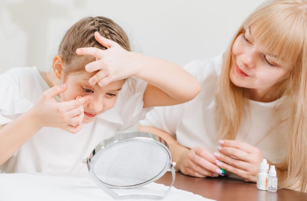A parent supervises as their child puts in their multifocal contact lenses.