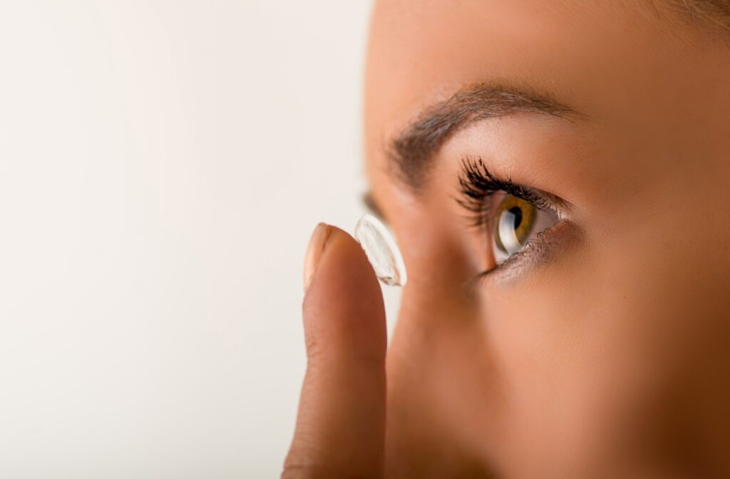 A close up of someone putting a contact lens in to their eye